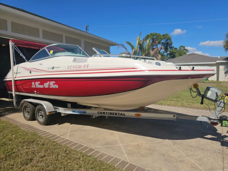 Slide: The Image of 2012 Godfrey Hurricane 217 Sundeck boat on trailer in front of garage. - 27