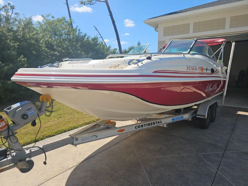 Slide: The Image of 2012 Godfrey Hurricane 217 Sundeck boat on trailer in front of garage. - 6