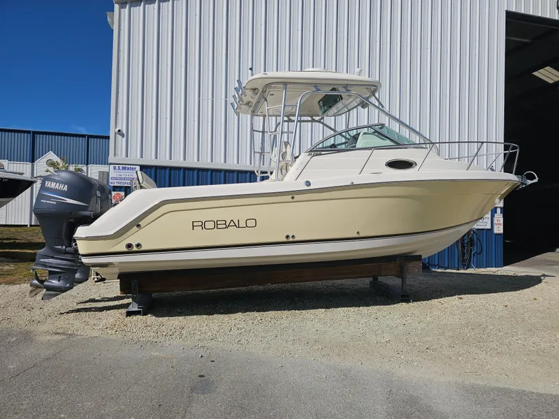 Slide: The Image of 2006 Robalo R265 Walkaround boat outside warehouse. - 43