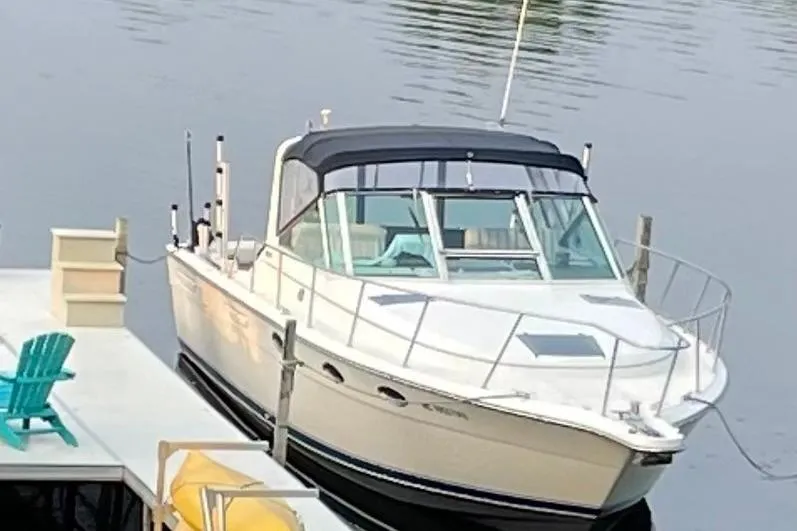 The Image of 1991 Tiara Yachts 3100 Open docked by a serene waterfront. - 0