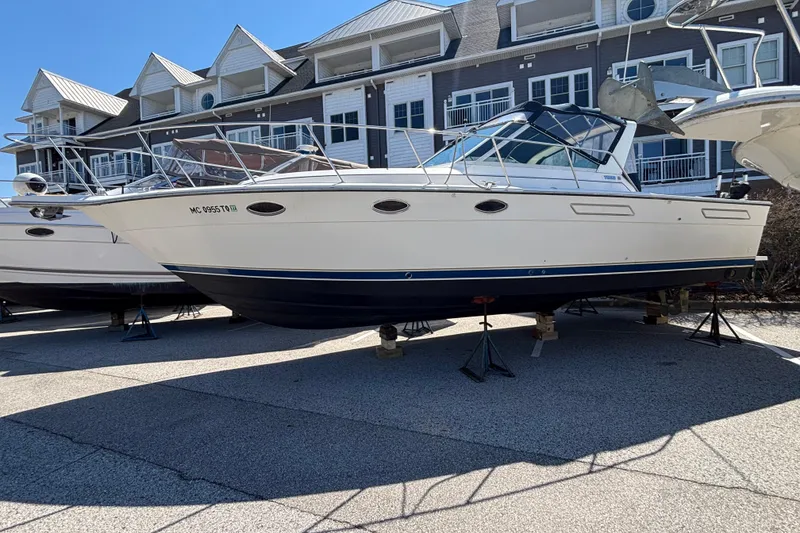 Slide: The Image of 1991 Tiara Yachts 3100 Open boat on stands, in front of a building. - 1