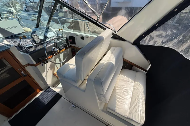 Slide: The Image of 1991 Tiara Yachts 3100 Open helm with white seating and Garmin navigation system. - 10
