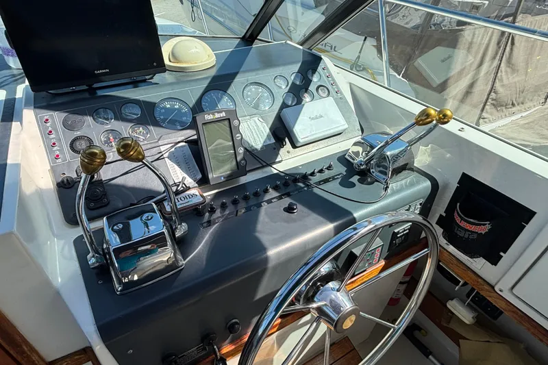 Slide: The Image of 1991 Tiara Yachts 3100 Open helm with controls, gauges, and navigation equipment. - 11