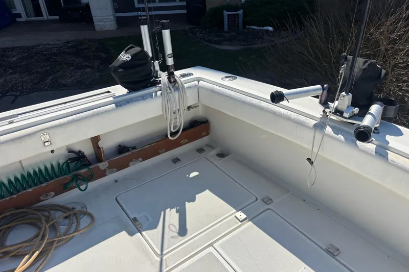 Slide: The Image of 1991 Tiara Yachts 3100 Open deck with fishing rod holders and coiled ropes. - 13