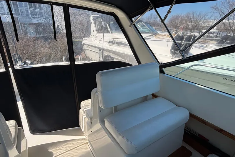 Slide: The Image of Interior of a 1991 Tiara Yachts 3100 Open, featuring white seating and large windows. - 16
