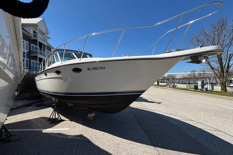 Slide: The Image of 1991 Tiara Yachts 3100 Open boat on stands, parked near buildings and trees. - 2