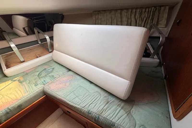 Slide: The Image of 1991 Tiara Yachts 3100 Open cabin interior with cushioned seating and storage. - 23