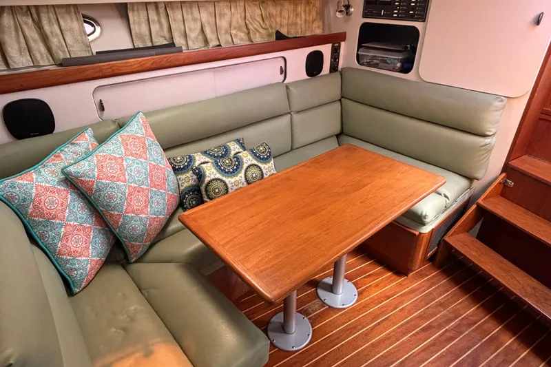 Slide: The Image of Interior of 1991 Tiara Yachts 3100 Open with cushioned seating and wooden table. - 24