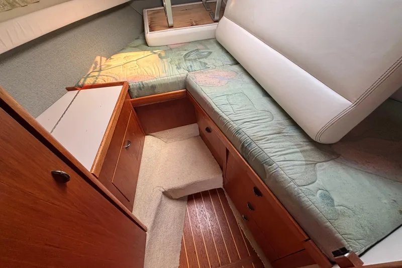Slide: The Image of 1991 Tiara Yachts 3100 Open cabin interior with wooden cabinetry and cushioned seating. - 27