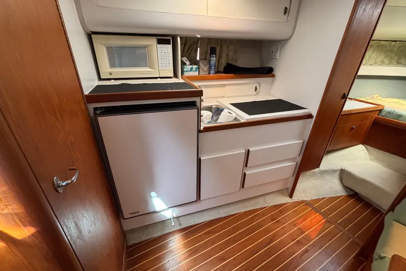Slide: The Image of 1991 Tiara Yachts 3100 Open interior with kitchenette, featuring microwave and mini fridge. - 29