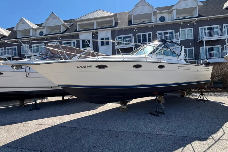 Slide: The Image of 1991 Tiara Yachts 3100 Open boat on stands, in front of residential buildings. - 3