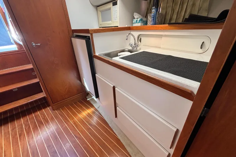 Slide: The Image of 1991 Tiara Yachts 3100 Open interior with wooden flooring, kitchenette, and storage. - 31