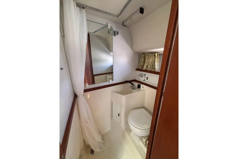 Slide: The Image of Bathroom interior of 1991 Tiara Yachts 3100 Open, featuring sink and toilet. - 34