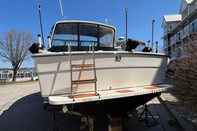 Slide: The Image of 1991 Tiara Yachts 3100 Open boat on dry dock near marina and residential buildings. - 4