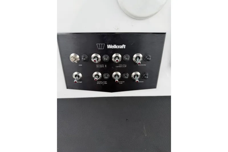 Slide: The Image of Control panel of a 2021 Wellcraft 202 Fisherman boat with various switches. - 12