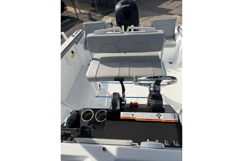 Slide: The Image of 2021 Wellcraft 202 Fisherman boat interior with steering wheel and seating area. - 9