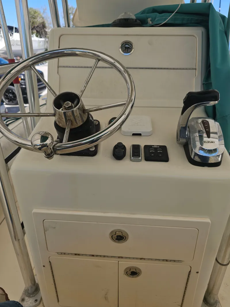 Slide: The Image of Control console of a 2000 Dorado 23 boat with steering wheel and throttle. - 15