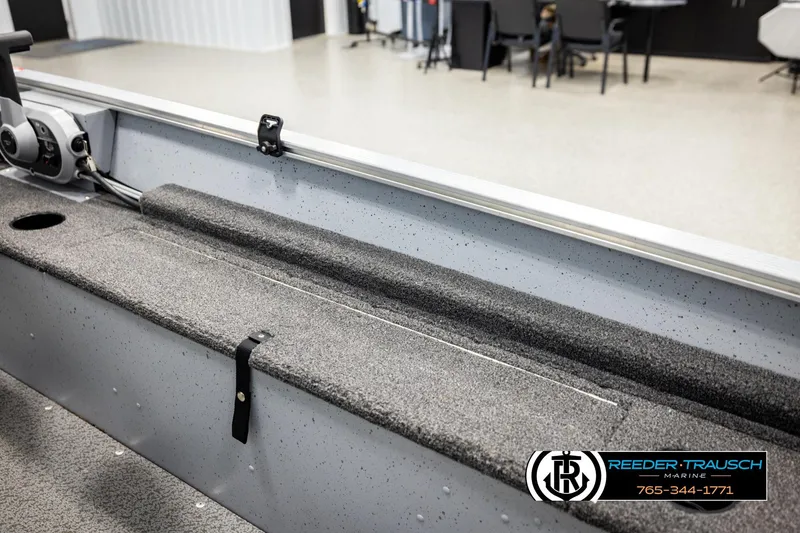 Slide: The Image of 2025 Lund 1600 Fury SS boat interior with steering console and carpeted flooring. - 17