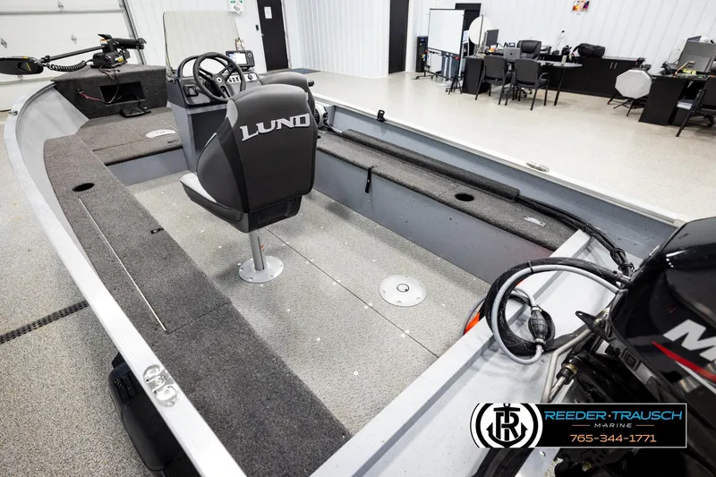 Slide: The Image of 2025 Lund 1600 Fury SS boat interior with steering console and seating in showroom. - 9