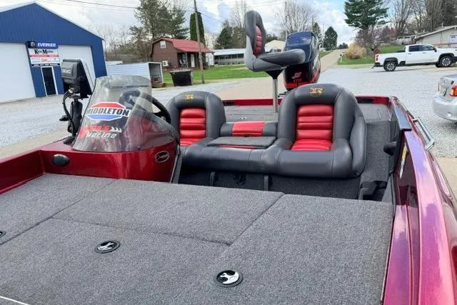 Slide: The Image of 1999 Ranger 461VS boat with red and black seating, parked outdoors near buildings. - 12