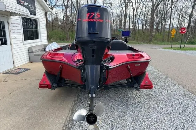 Slide: The Image of Red 1999 Ranger 461VS boat with Mercury 175 engine, parked on gravel near a building. - 4