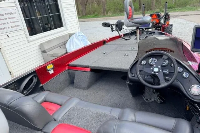 Slide: The Image of 1999 Ranger 461VS boat interior with steering console and seating, parked near a building. - 8