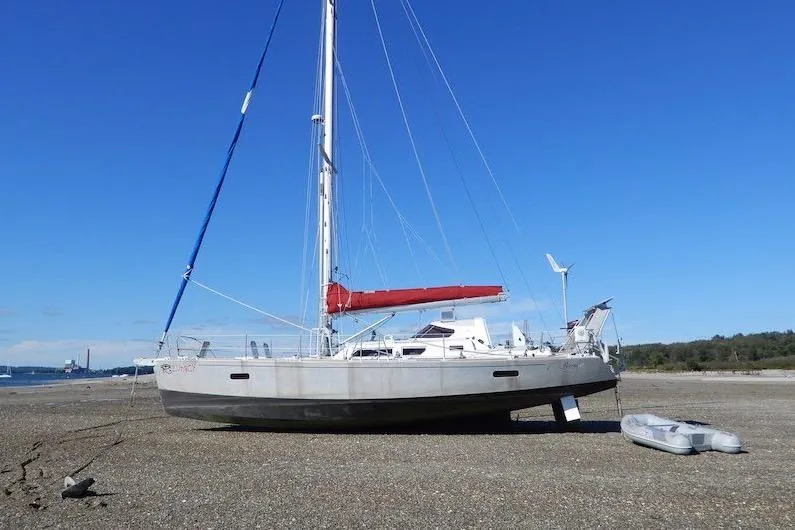 The Image of Sailboat Boreal 47 (2017) beached on a rocky shore with clear blue sky. - 0