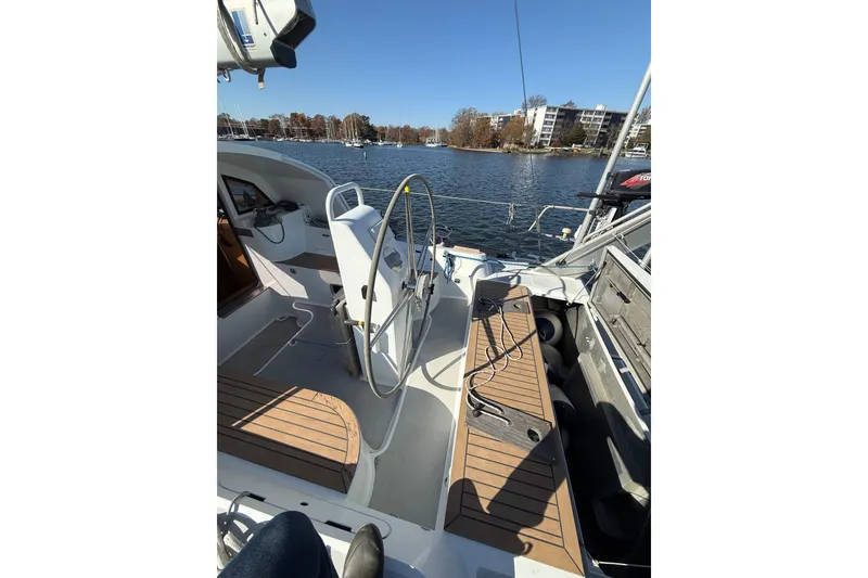 Slide: The Image of Cockpit of 2017 Boreal 47 sailboat with wooden seating, steering wheel, and waterfront view. - 12
