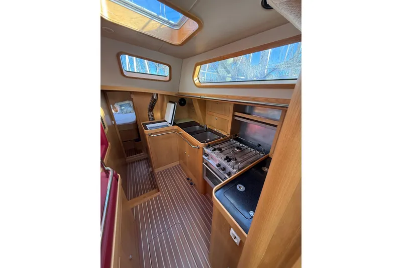 Slide: The Image of Interior of 2017 Boreal 47 yacht, featuring a modern kitchen with wood finish. - 24