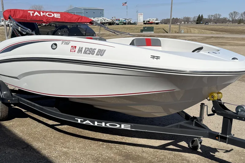 Slide: The Image of 2021 Tahoe T16 boat on trailer with red canopy, parked outdoors. - 2