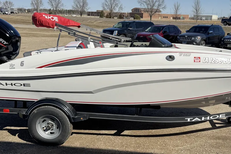 Slide: The Image of 2021 Tahoe T16 boat on trailer, parked outdoors with cover and visible registration. - 3