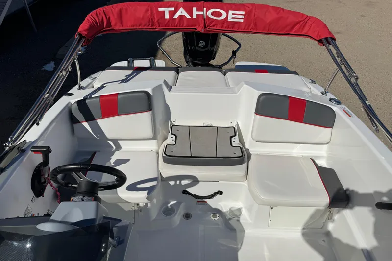 Slide: The Image of 2021 Tahoe T16 boat interior with red and gray seating, steering wheel, and canopy. - 8
