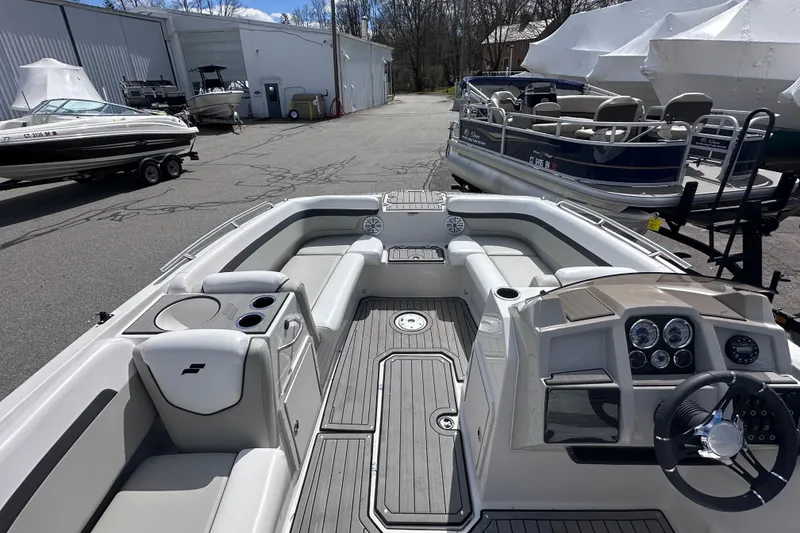 Slide: The Image of 2023 Starcraft SVX 191 OB boat interior with seating and control panel in a marina. - 11