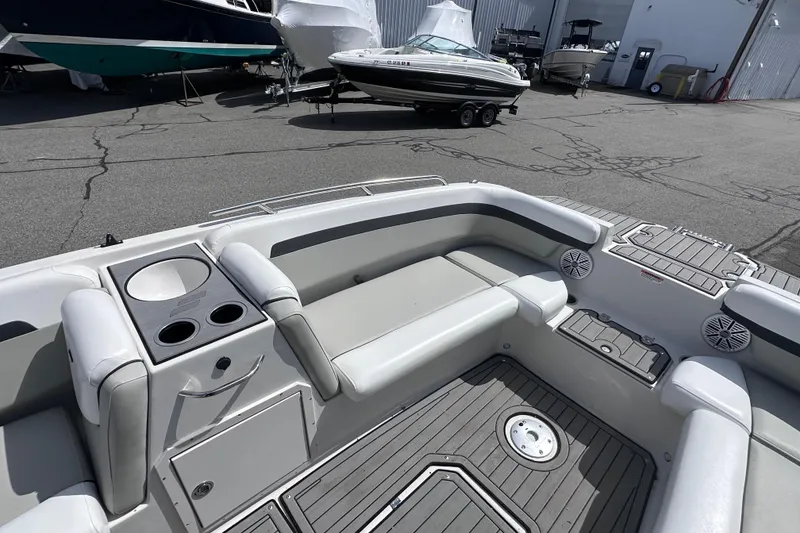 Slide: The Image of 2023 Starcraft SVX 191 OB boat interior with seating and cup holders in a marina setting. - 12