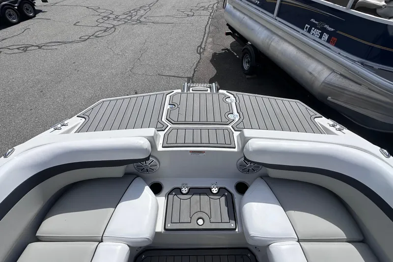 Slide: The Image of 2023 Starcraft SVX 191 OB boat interior with gray seating and deck, docked beside another boat. - 14