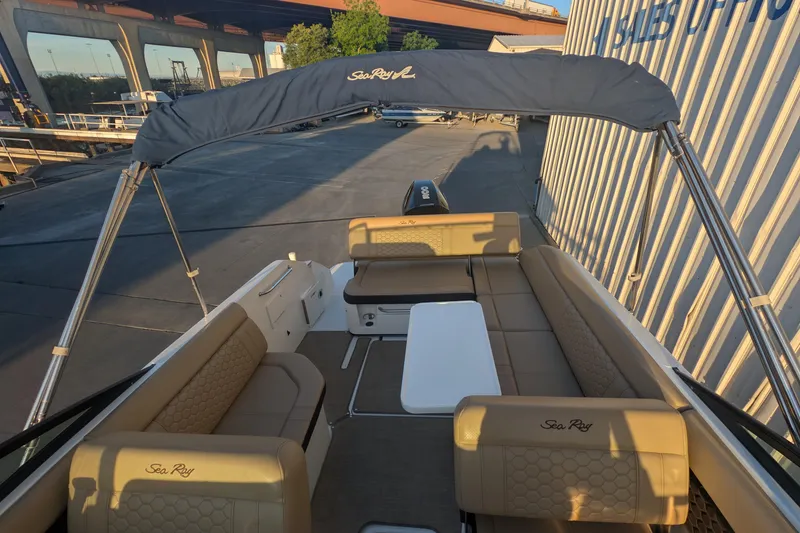 Slide: The Image of 2022 Sea Ray SDX 250 Outboard boat interior with tan seating and canopy. - 10