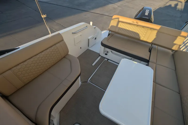 Slide: The Image of 2022 Sea Ray SDX 250 Outboard interior with beige seating and white table. - 11