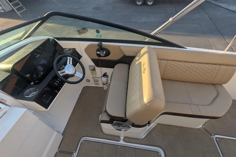 Slide: The Image of 2022 Sea Ray SDX 250 Outboard helm with beige seating and steering wheel. - 14
