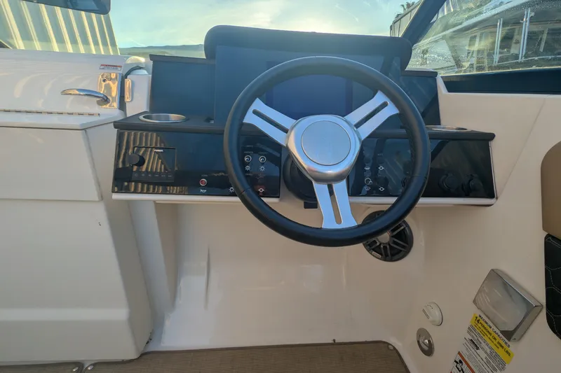 Slide: The Image of 2022 Sea Ray SDX 250 Outboard helm with steering wheel and control panel. - 18