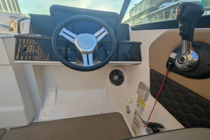 Slide: The Image of 2022 Sea Ray SDX 250 Outboard helm with steering wheel and control panel. - 19