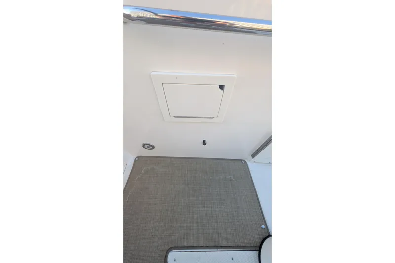 Slide: The Image of 2022 Sea Ray SDX 250 Outboard boat interior with storage compartment and non-slip flooring. - 25