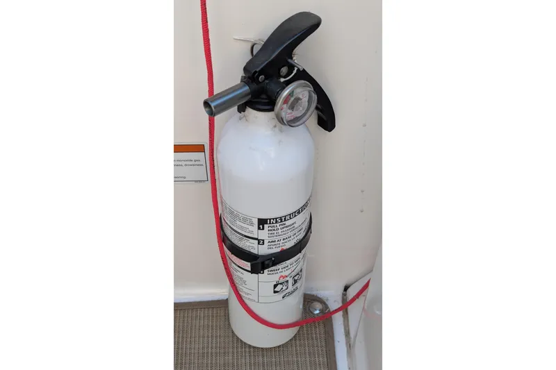 Slide: The Image of Fire extinguisher on 2022 Sea Ray SDX 250 Outboard boat, secured with red strap. - 30