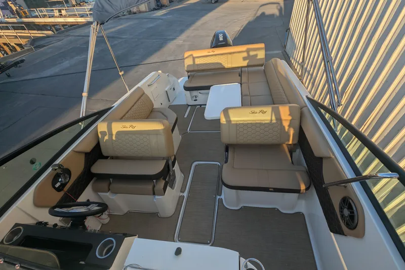Slide: The Image of 2022 Sea Ray SDX 250 Outboard boat interior with beige seating and steering console. - 9
