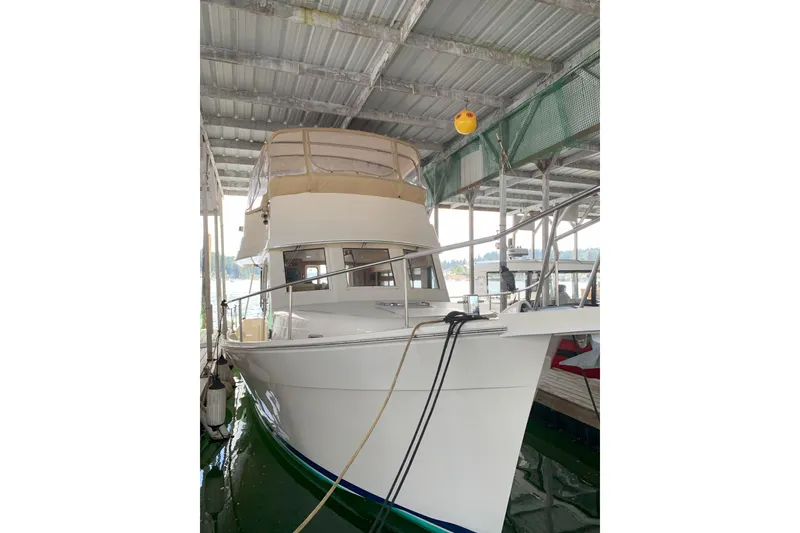 The Image of 2007 Mainship 34 Trawler docked under a covered marina. - 0