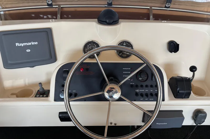 Slide: The Image of 2007 Mainship 34 Trawler helm with Raymarine E80 display and steering wheel. - 11
