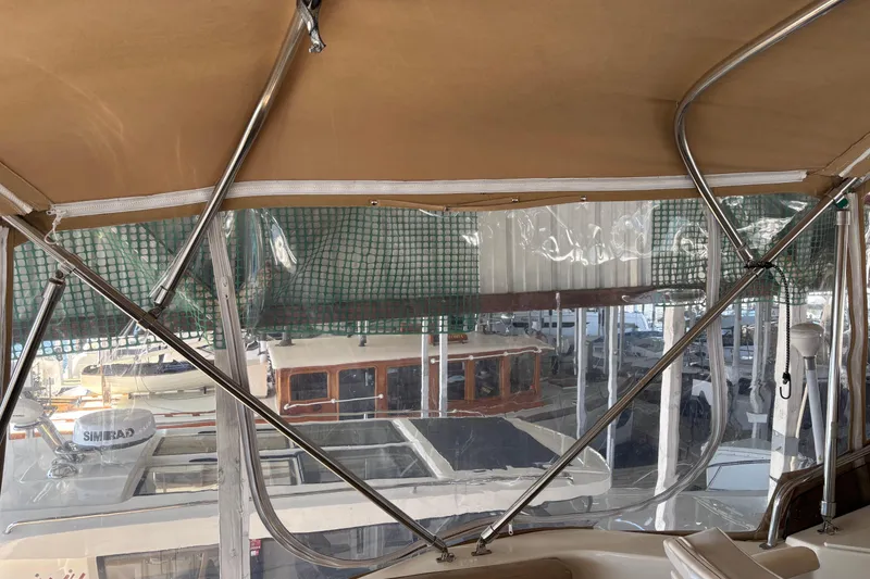 Slide: The Image of 2007 Mainship 34 Trawler interior view with canopy and marina background. - 13