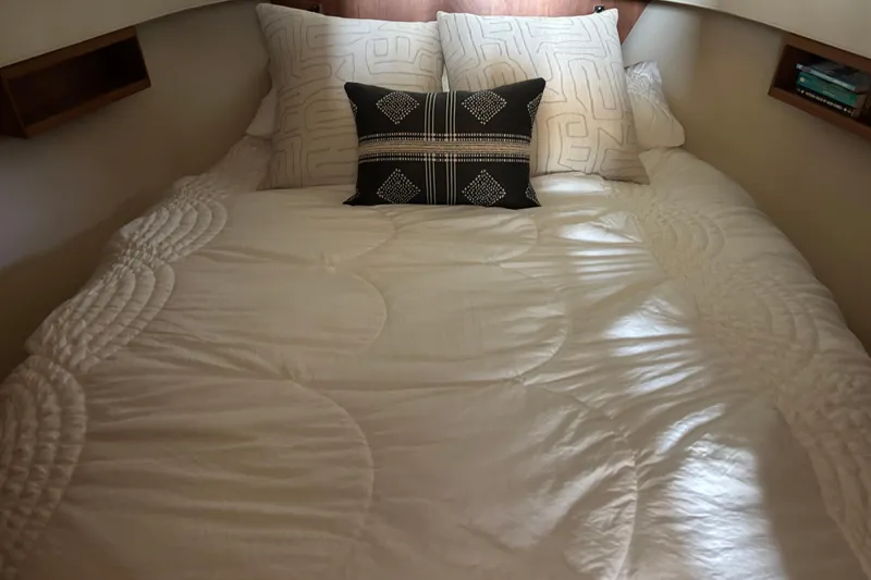 Slide: The Image of Cozy bed in 2007 Mainship 34 Trawler cabin with decorative pillows and soft lighting. - 25