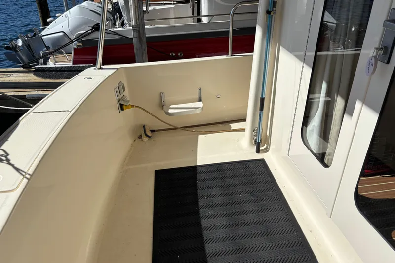 Slide: The Image of 2007 Mainship 34 Trawler deck area with black mat and docked boat view. - 7