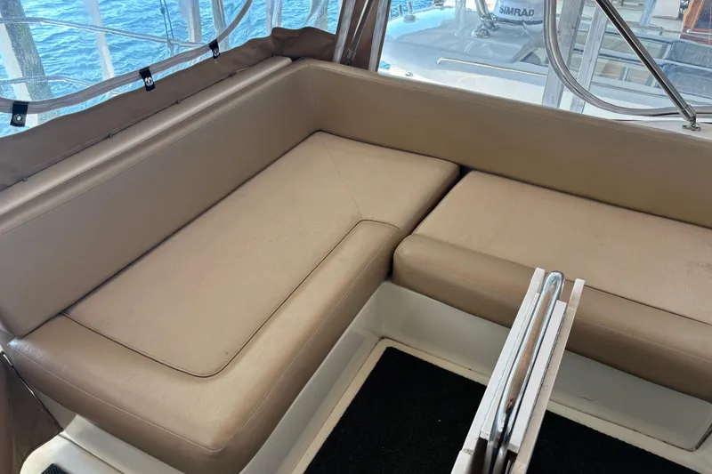 Slide: The Image of 2007 Mainship 34 Trawler interior with beige seating and window view. - 9