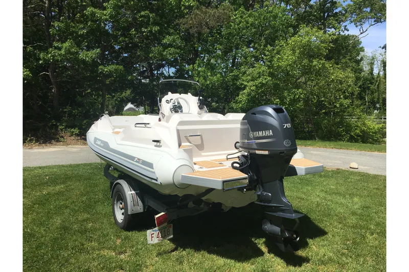 Slide: The Image of 2018 Zar Formenti 49 SL boat with Yamaha 70 engine on a trailer, parked on grass. - 12